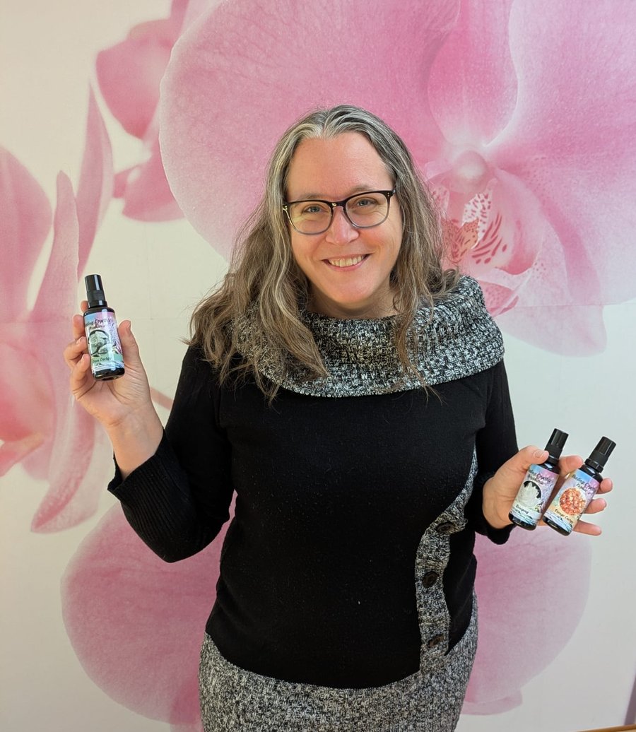 Mag. Angela Binder, Gründerin von LEBENS-QI, hält Aura-Sprays in den Händen